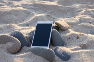 cellphone-on-the-beach-employees-who-cant-disconnect-sundance-vacations-the-benefit-of-travel-in-the-workplace