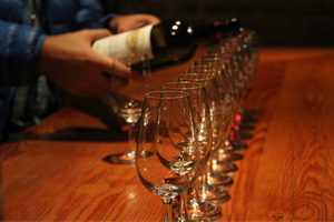 Close-up of wine being poured into multiple glasses